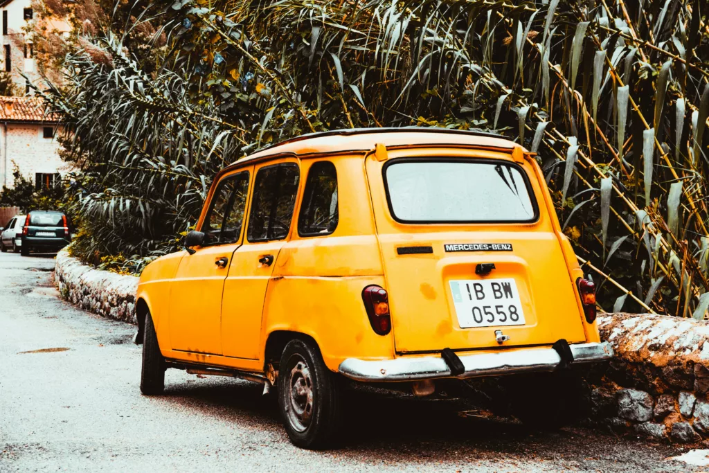 classic-yellow-car-on-side-of-road-at-day