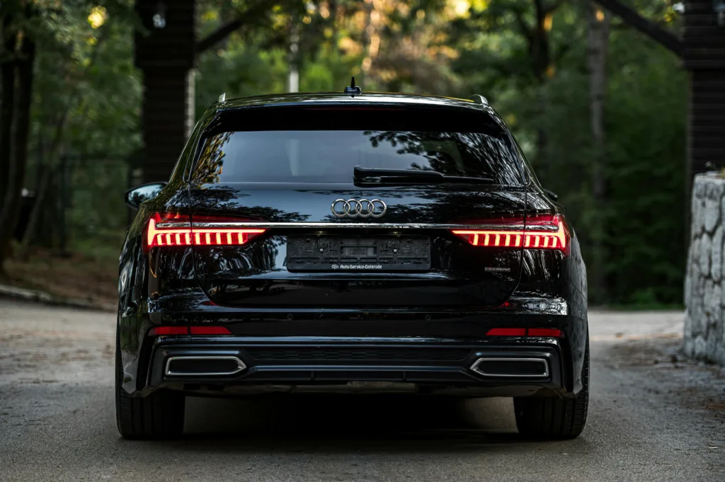 Sleek Black Luxury Car in Forest Driveway