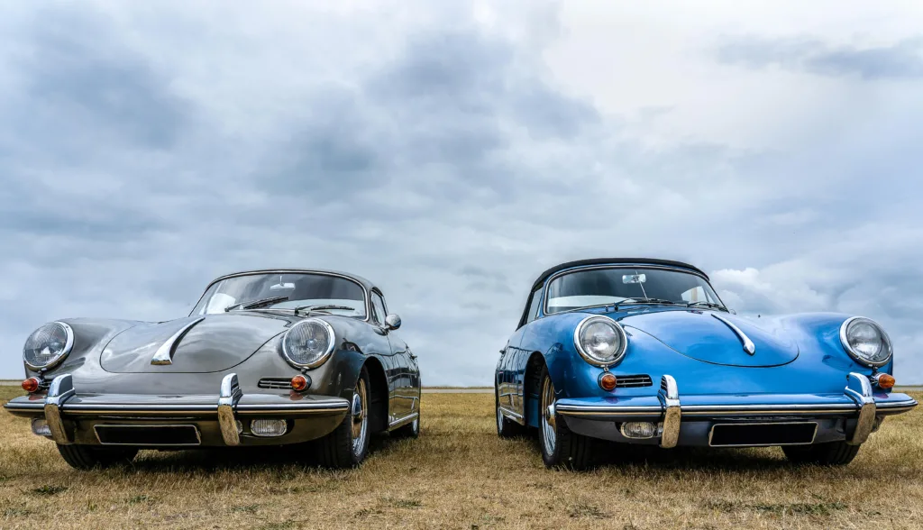 Vintage Cars on Green Grass Field Under White Clouds