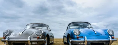 Vintage Cars on Green Grass Field Under White Clouds