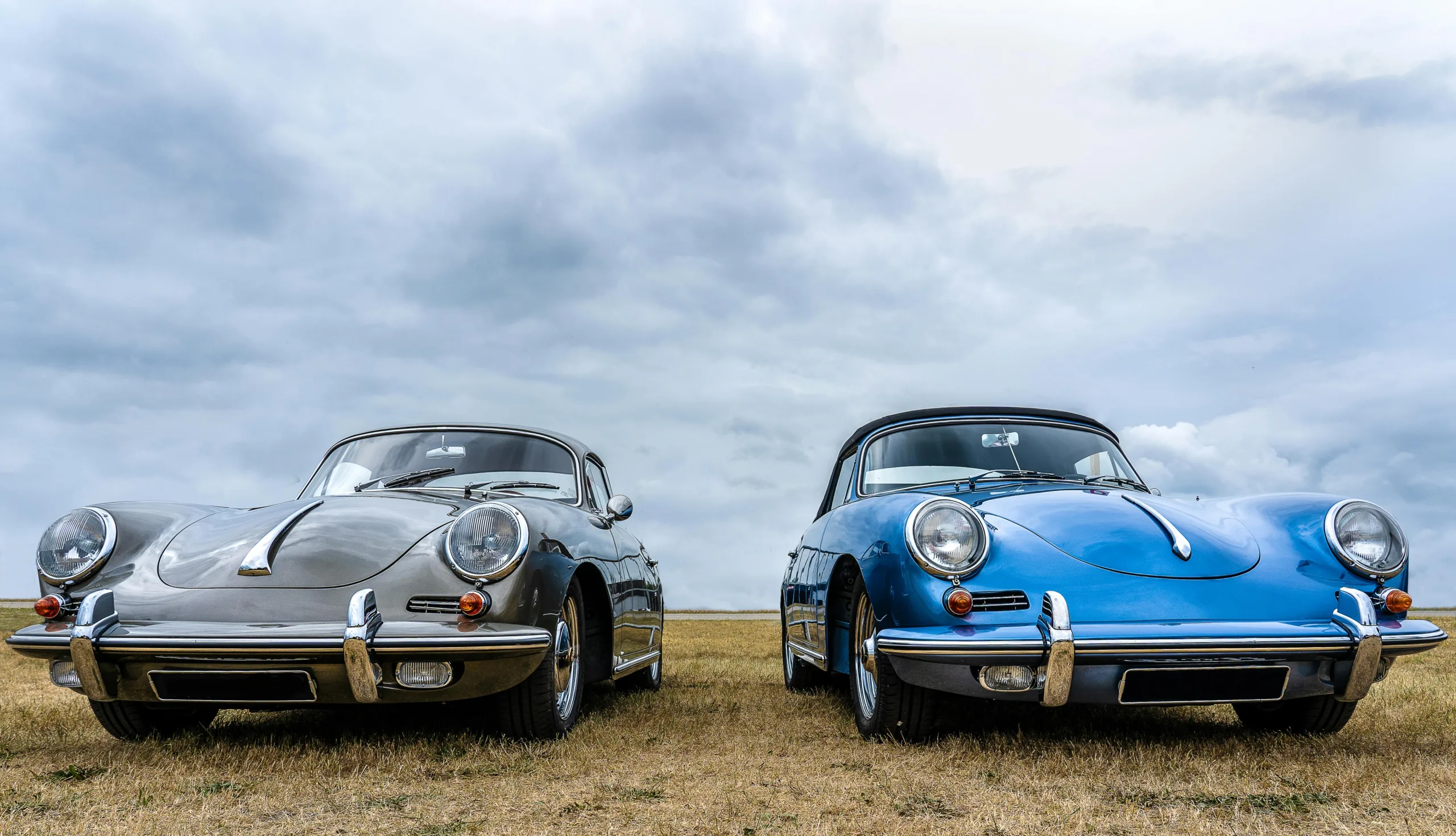 Vintage Cars on Green Grass Field Under White Clouds