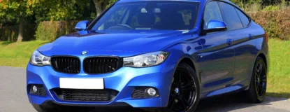 Blue Bmw Sedan Near Green Lawn Grass