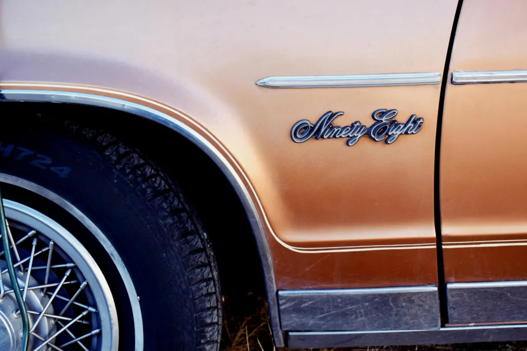 Close-up of an orange Oldsmobile Ninety-Eight showing vintage design details.