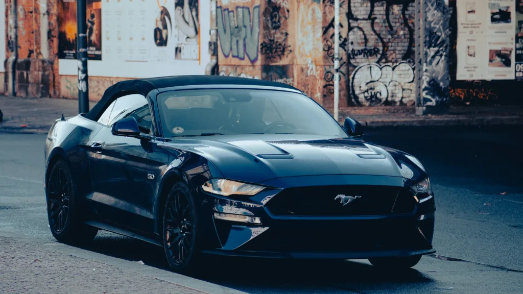 A dark blue convertible sports car parked on a street.