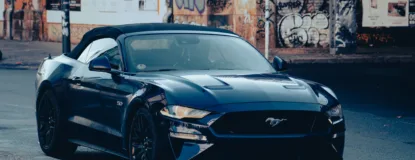 A dark blue convertible sports car parked on a street.
