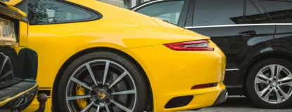 two yellow and black vehicles parked near gray concrete building