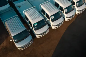 Aerial view of white pickup trucks aligned neatly in a parking lot.