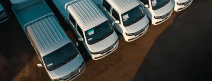 Aerial view of white pickup trucks aligned neatly in a parking lot.