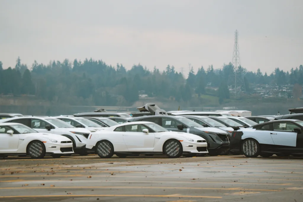 Wide shot of multiple sports cars parked outdoors on a cloudy day.
