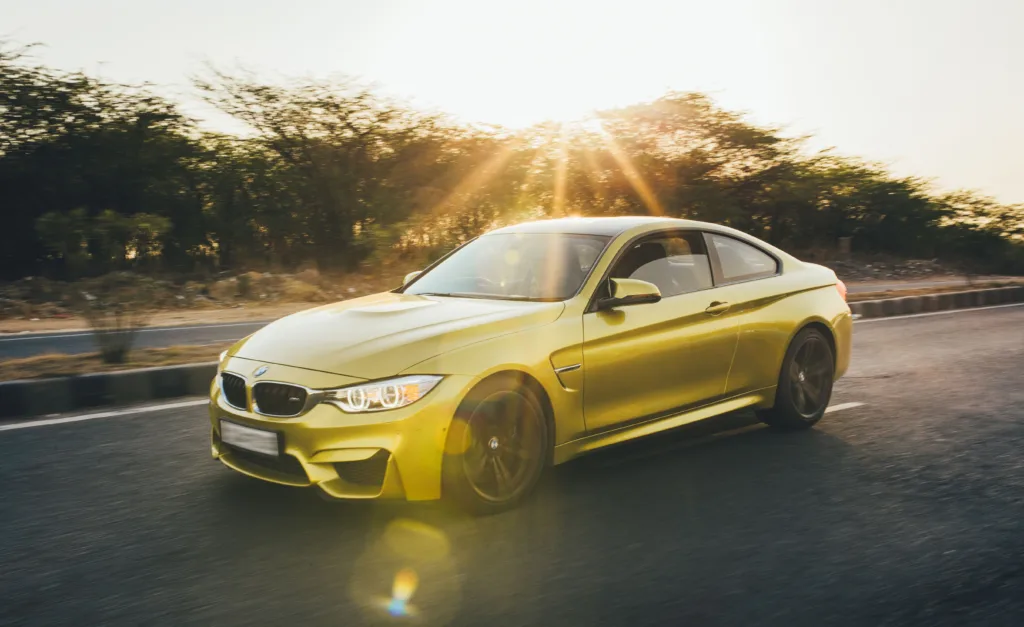 Yellow sports car speeding along a road.