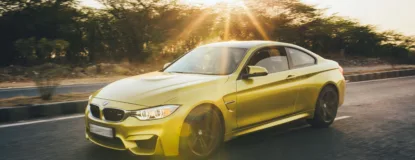 Yellow sports car speeding along a road.