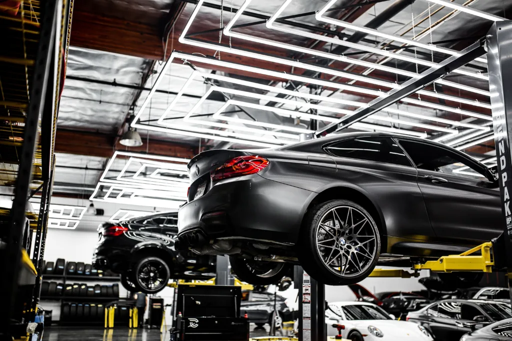 A modern car repair shop showcasing vehicles on lifts and a well-lit